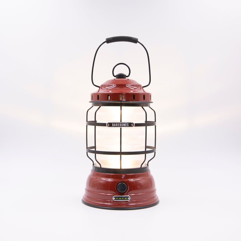 Image shows a traditional camping lantern with a red finish.