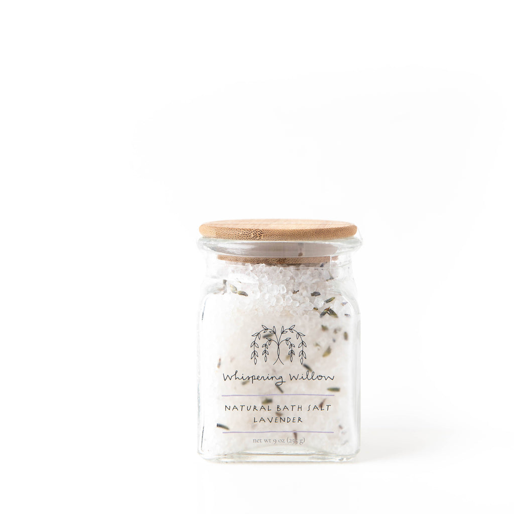 Clear glass jar of white salt with lavender buds interspersed. 