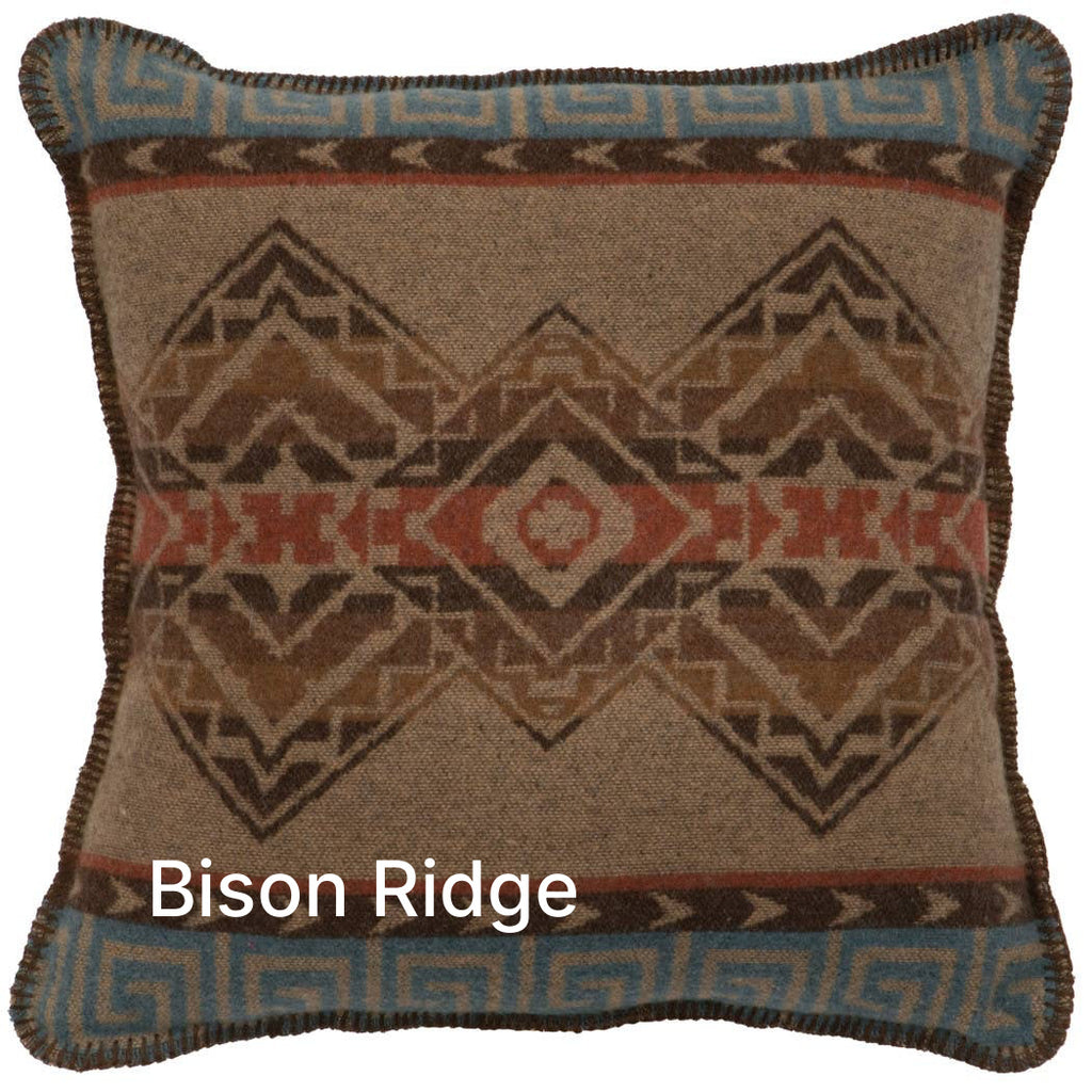 Image displays predominantly brown pillow with geometric patterns across the front, along with blue accents on the top and bottom of the pillow.