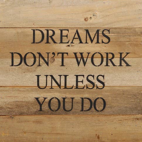 Image shows a natural wood sign. Text reads "Dreams don't work unless you do."