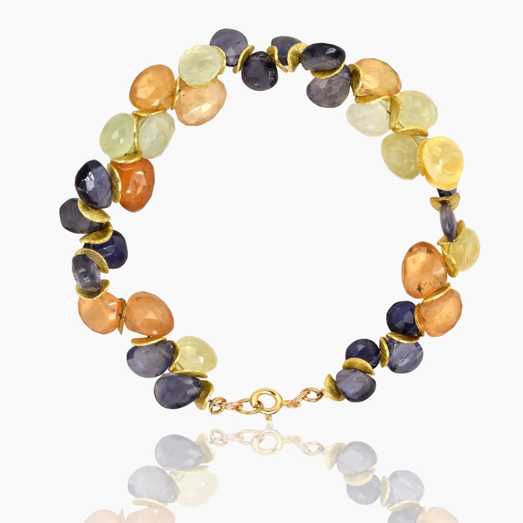 Image shows a bracelet of black, orange, and yellow stones alternating with gold discs on a white background.