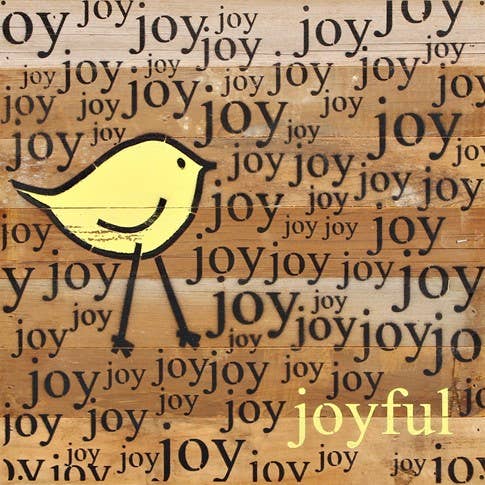 Image shows a natural wood sign. Text reads "joy" repeatedly with a yellow bird stick figure.