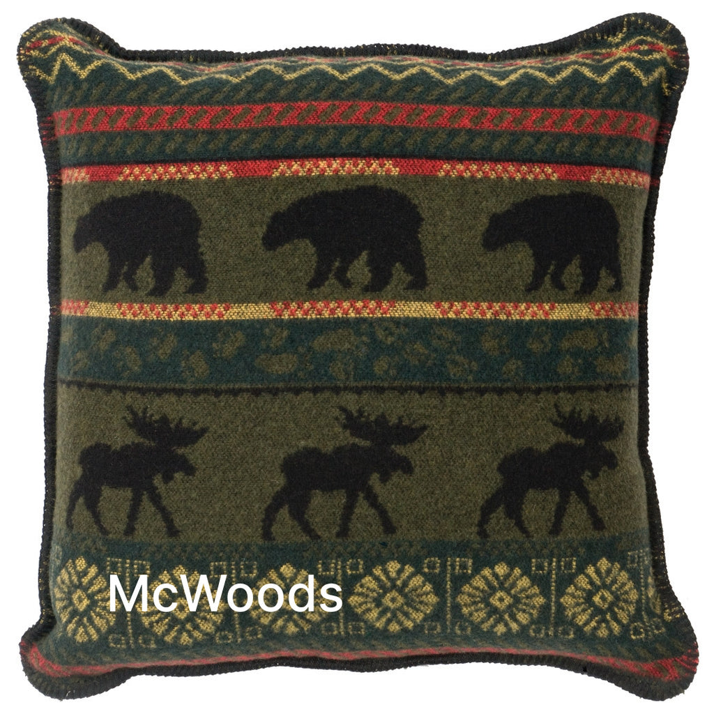 Image shows a predominantly green pillow with black silhouettes of bears and moose in stripes across the length of the pillow.