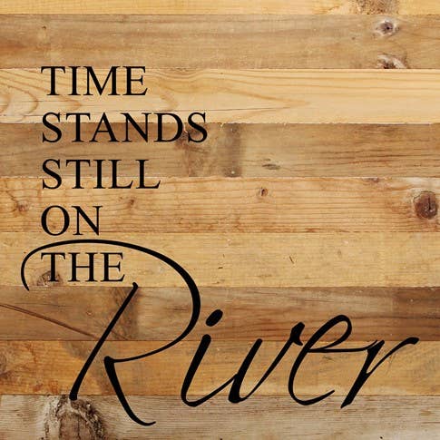 Image shows a natural wood sign. Text reads "Time stands still on the river".