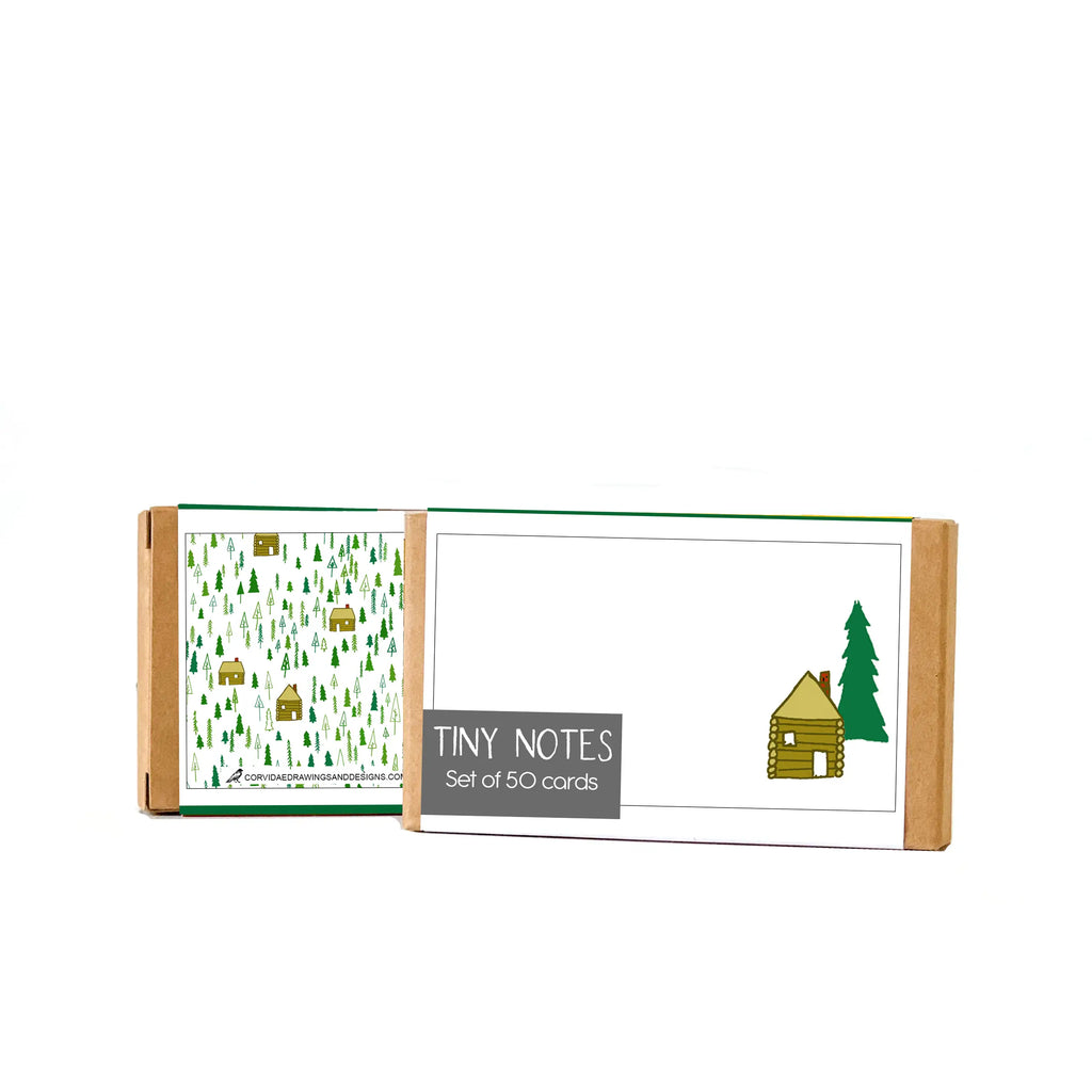 Picture shows the front and back of the "Cabin" Tiny Notes on a white background. Front shows single drawn image of the front view of a cabin with a nearby tree on a white background. The back has scattered cabins and trees.